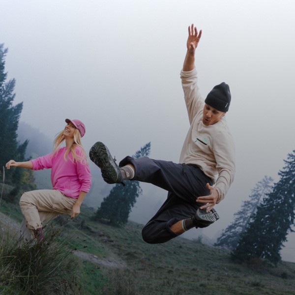 Two friends are jumping on a hill