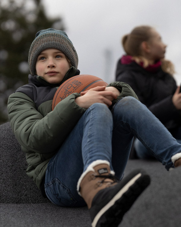 Boy sitting and holding a basketball